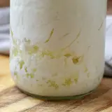 Kefir-Körner im Glas, bereit zum Kefir einfrieren. Die Körner sind von einer cremigen Masse umgeben.