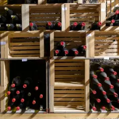 Weinlager mit vielen Flaschen in Holzkisten. Manche Flaschen haben rote Kappen. Die Frage, ob Wein ein Ablaufdatum hat, bleibt offen.