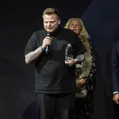 Mann mit Mikrofon und Trophäe, der als bester Koch der Welt gefeiert wird.