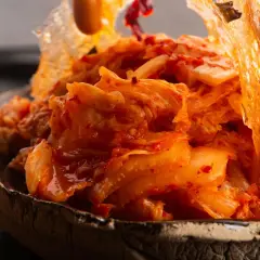 Nahaufnahme von würzigem, fermentiertem Chinakohl, der in einer Schüssel serviert wird. Dieses kimchi ohne fischsauce ist ein Genuss für Veganer.
