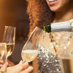 Sekt wird in Gläser gegossen. Die Frage, was ist der Unterschied zwischen Sekt und Champagner, beschäftigt viele Genießer.