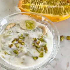 Kiwano-Rezept: Cremiges Dessert mit Banane, Cashews und Pistazien, garniert mit einer halbierten Kiwano-Frucht.