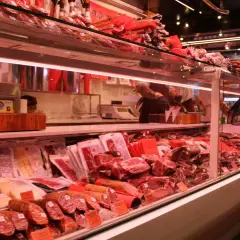 Fleischtheke mit rohem Schweinefleisch, Schinken und Wurst. Hier kann man sich vorstellen, wie man das schwein roh essen könnte, aber es ist besser, es zu kochen.