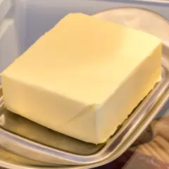 Ein Block Butter auf einem Butterfass im Kühlschrank. Die Frage "wie lange kann man Butter einfrieren?" beschäftigt viele.
