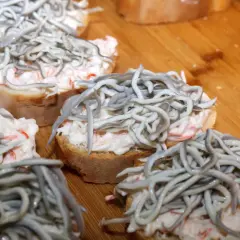 Kleine Brotscheiben mit cremiger Füllung und einem Haufen glas aal.