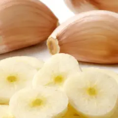 Frische Knoblauchzehen und Scheiben. Woran erkennt man schlechten Knoblauch? An weichen Zehen und verfärbten, matschigen Scheiben.