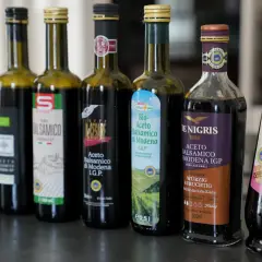 Reihe von Flaschen mit Aceto Balsamico di Modena, darunter Bio-Aceto Balsamico und Hengstenberg Feine Essige.