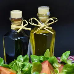 Zwei Flaschen Öl und Essig, daneben ein Salat. Wenn du zu viel Essig hast, was tun? Weniger nehmen!