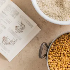 Kichererbsen und eine Schüssel mit Getreide, bereit für die Zubereitung von Miso. Das Rezept erklärt, woraus Miso besteht: Sojabohnen, Koji und Salz.