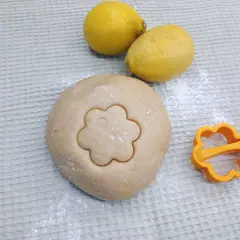 Teig für Canestrini mit Zitronen und Ausstecher in Blumenform.