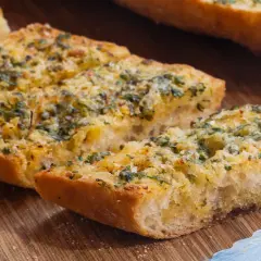 Knoblauchbrot selbst machen ist einfach! Hier sind knusprige Scheiben Baguette mit Butter, Knoblauch und Kräutern belegt, bereit zum Genießen.