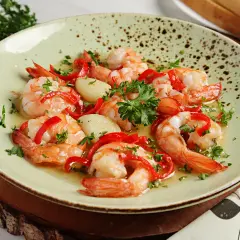 Garnelen in Knoblauchöl mit Paprika und Petersilie, ein köstliches Gericht, das perfekt zu einem Glas Wein passt.