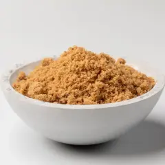 Schüssel mit dunklem Muscovado-Zucker, dessen feine Körner eine warme, karamellige Farbe haben.