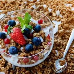 Knuspriges Granola mit Beeren und Kokosflocken in einer Schale. Was ist Granola? Ein leckeres Frühstück!