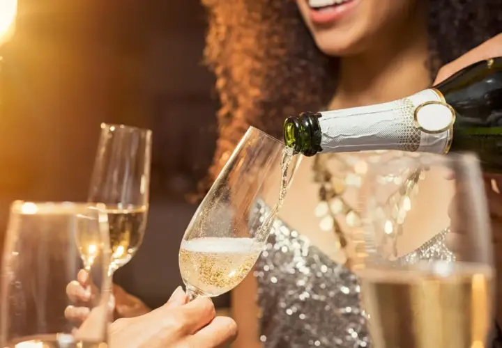 Sekt wird in Gläser gegossen. Die Frage, was ist der Unterschied zwischen Sekt und Champagner, beschäftigt viele Genießer.