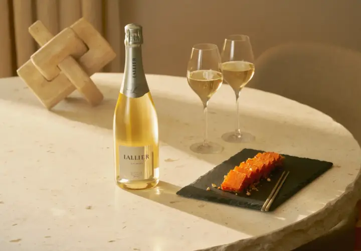 LALLIER Blanc de Blancs Champagner mit zwei Gläsern und einem Holzpuzzle.