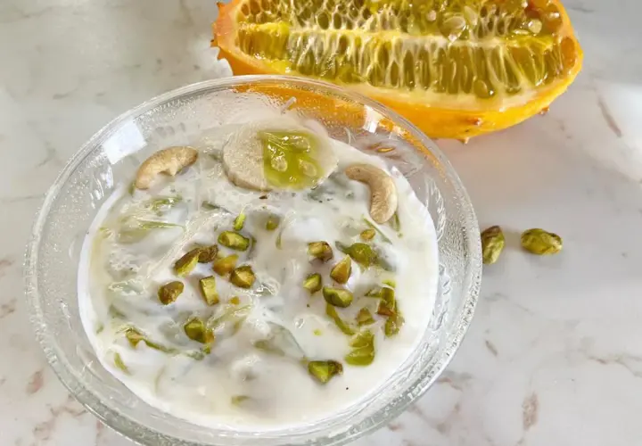 Kiwano-Rezept: Cremiges Dessert mit Banane, Cashews und Pistazien, garniert mit einer halbierten Kiwano-Frucht.