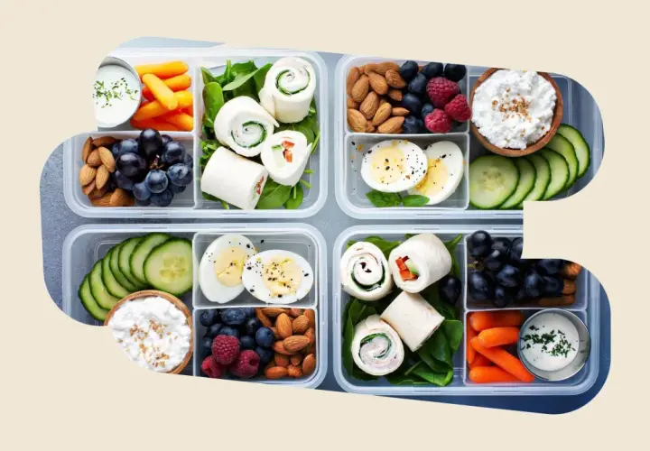 Vorbereitete Lunchboxen mit Wraps, Eiern, Beeren, Nüssen, Karotten und Gurken – perfekt als gesunde Snacks zum Mitnehmen.