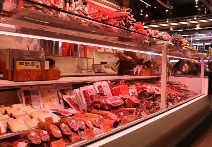 Fleischtheke mit rohem Schweinefleisch, Schinken und Wurst. Hier kann man sich vorstellen, wie man das schwein roh essen könnte, aber es ist besser, es zu kochen.