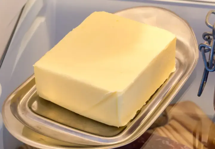 Ein Block Butter auf einem Butterfass im Kühlschrank. Die Frage "wie lange kann man Butter einfrieren?" beschäftigt viele.