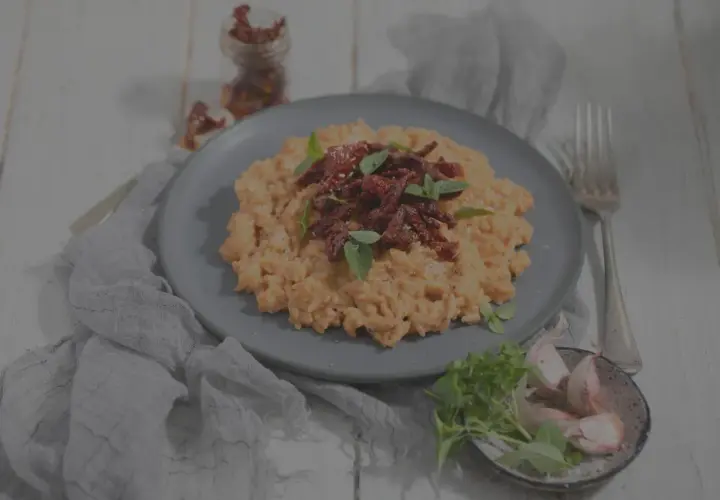 Cremiges Risotto mit getrockneten Tomaten und Basilikum. Man kann Risotto einfrieren, aber die Konsistenz verändert sich.
