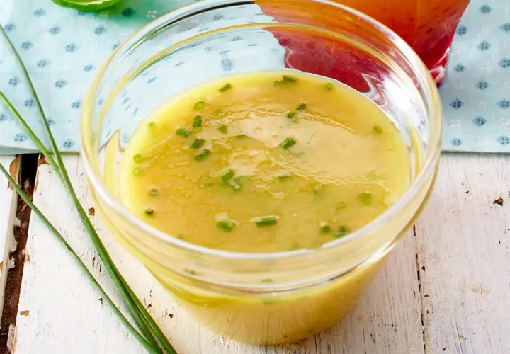 Ein Glas mit cremigem honig-senf-dressing wie im restaurant, garniert mit Schnittlauch.