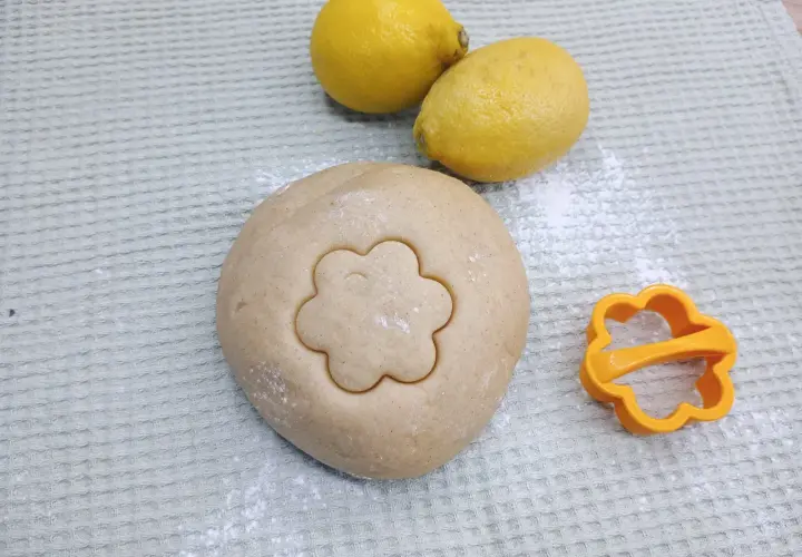 Teig für Canestrini mit Zitronen und Ausstecher in Blumenform.