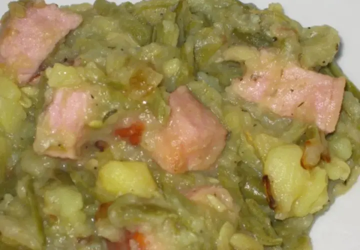 Ein herzhafter saure bohnen eintopf mit Kartoffeln und rosa Speckstücken, dampfend und bereit zum Genießen.