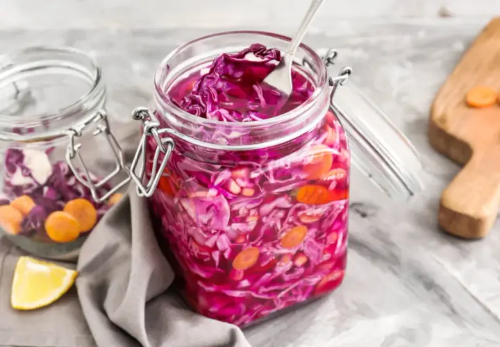 Fermentierter Rotkohl in Gläsern. Woran erkennt man das Rotkohl schlecht ist? Anzeichen sind Schimmel, unangenehmer Geruch oder matschige Konsistenz.