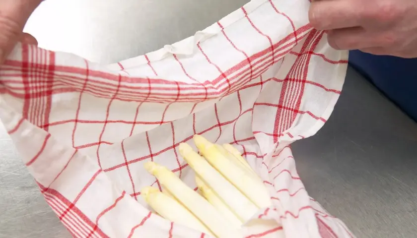 Gekochter Spargel in einem karierten Tuch. Wie lange haltbar? Frisch und appetitlich, bereit für die Lagerung.
