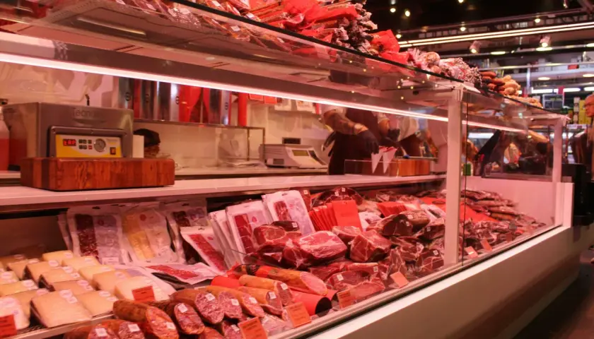 Fleischtheke mit rohem Schweinefleisch, Schinken und Wurst. Hier kann man sich vorstellen, wie man das schwein roh essen könnte, aber es ist besser, es zu kochen.