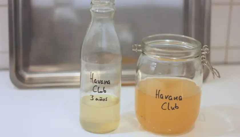 Zwei Gläser mit Flüssigkeit, beschriftet mit "Havana Club". Eines enthält eine hellere Flüssigkeit, das andere eine bernsteinfarbene. Vielleicht ein Experiment mit kahmhefe essig?