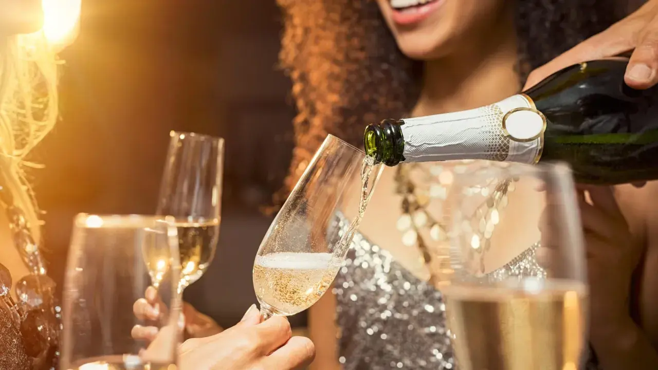 Sekt wird in Gläser gegossen. Die Frage, was ist der Unterschied zwischen Sekt und Champagner, beschäftigt viele Genießer.
