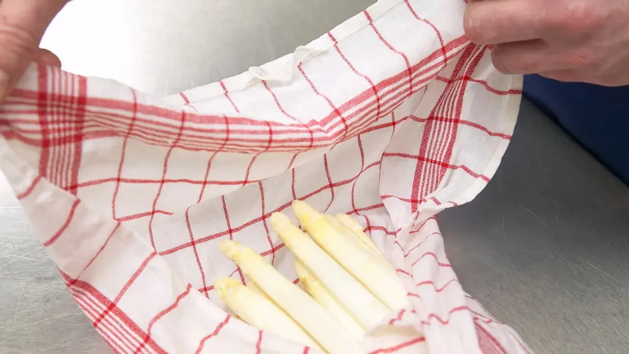 Gekochter Spargel in einem karierten Tuch. Wie lange haltbar? Frisch und appetitlich, bereit für die Lagerung.