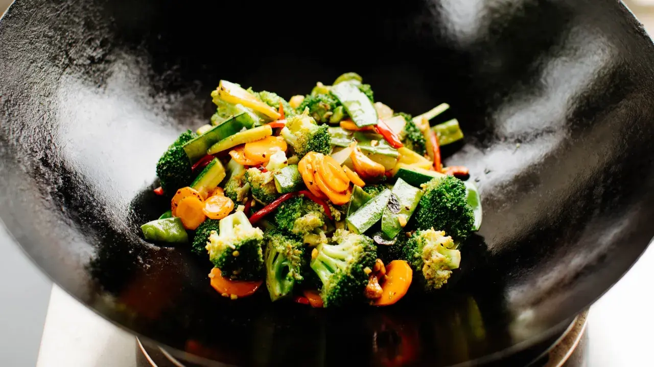 Buntes Gemüse (Brokkoli, Karotten, Zucchini) wird in einer Wokpfanne zubereitet. Ein schnelles und gesundes wok pfanne rezept.