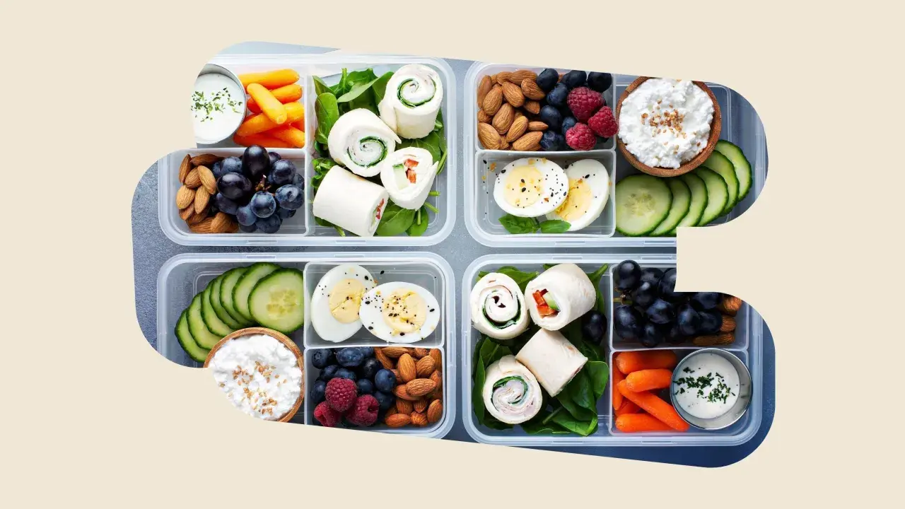 Vorbereitete Lunchboxen mit Wraps, Eiern, Beeren, Nüssen, Karotten und Gurken – perfekt als gesunde Snacks zum Mitnehmen.