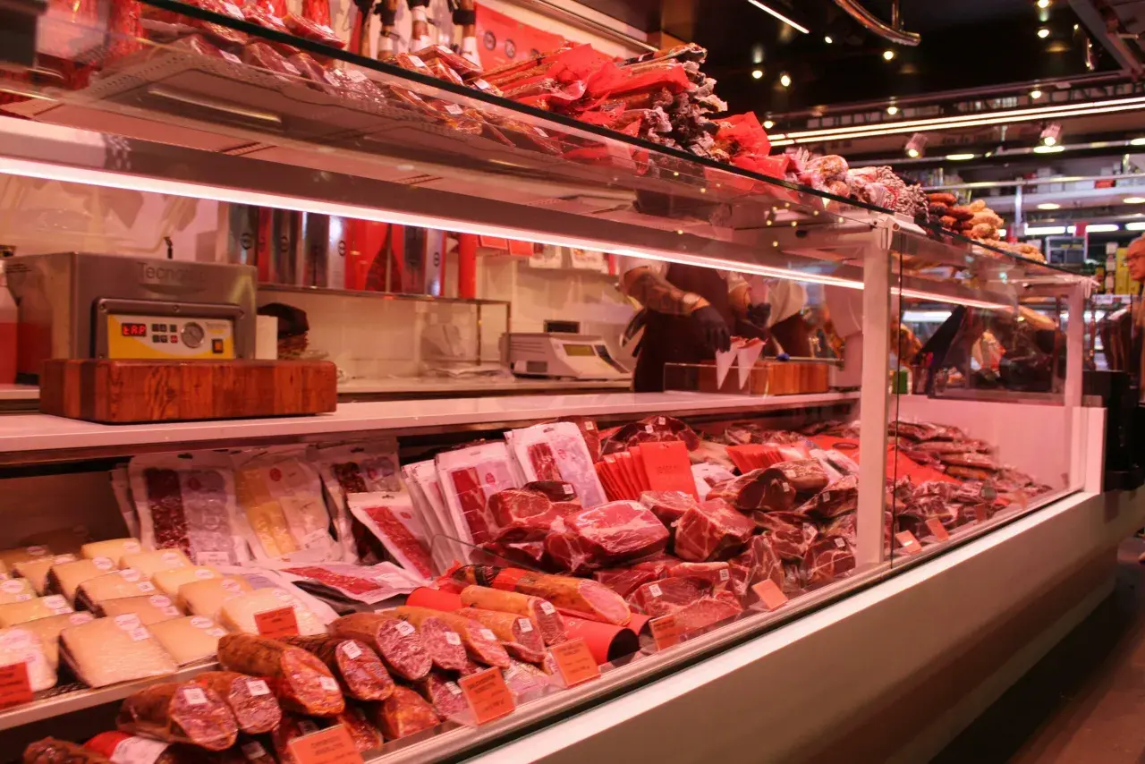 Fleischtheke mit rohem Schweinefleisch, Schinken und Wurst. Hier kann man sich vorstellen, wie man das schwein roh essen könnte, aber es ist besser, es zu kochen.