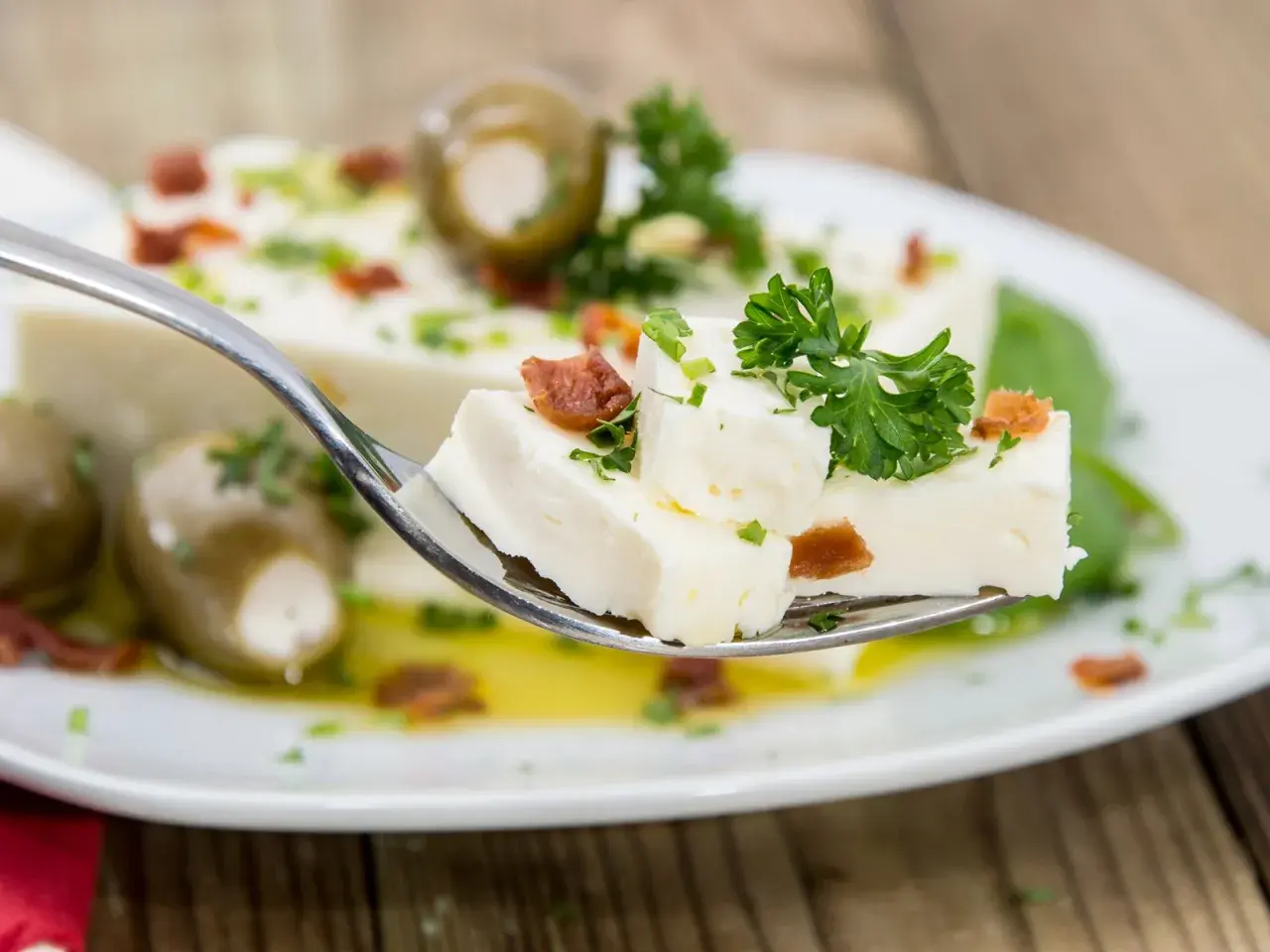 Ein Löffel mit selbstgemachtem Feta, Oliven und Kräutern. Frisch zubereitet und köstlich!