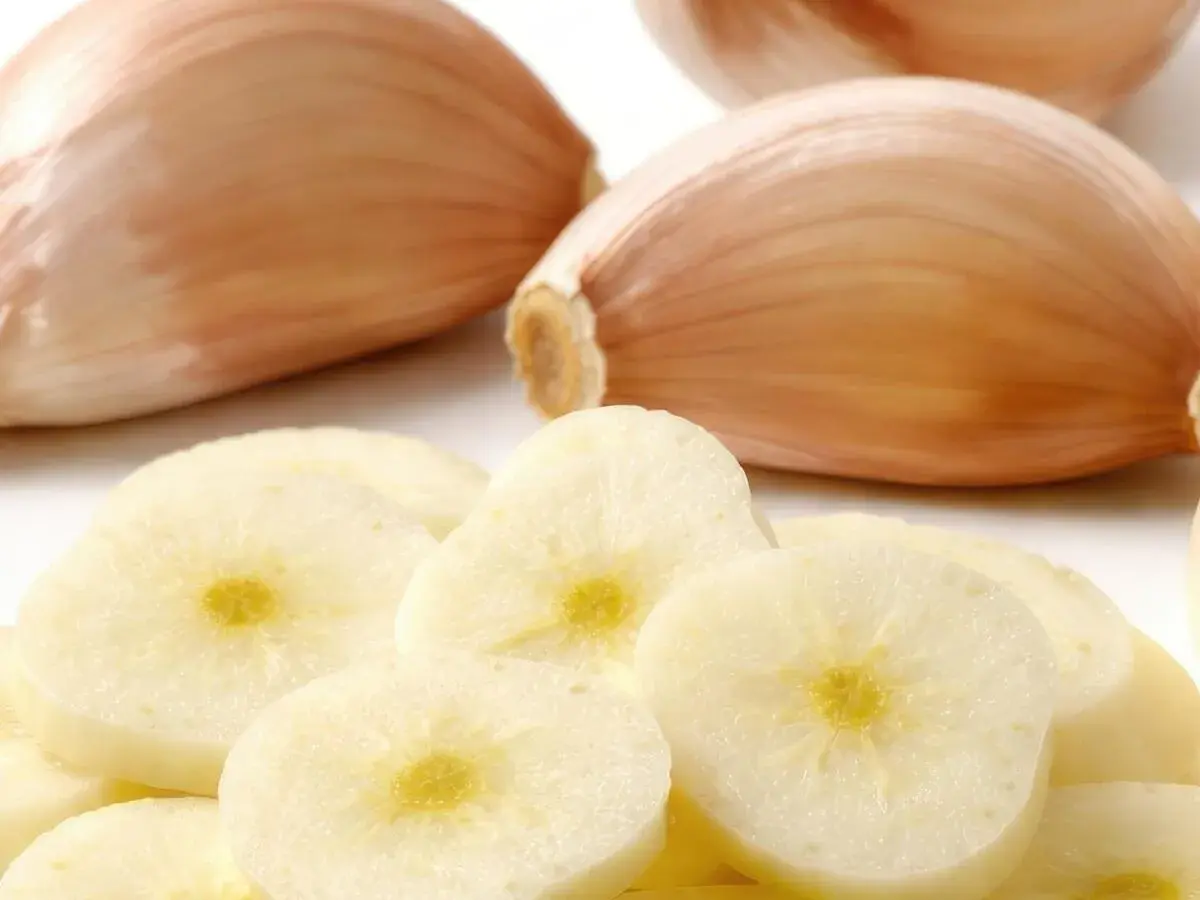 Frische Knoblauchzehen und Scheiben. Woran erkennt man schlechten Knoblauch? An weichen Zehen und verfärbten, matschigen Scheiben.