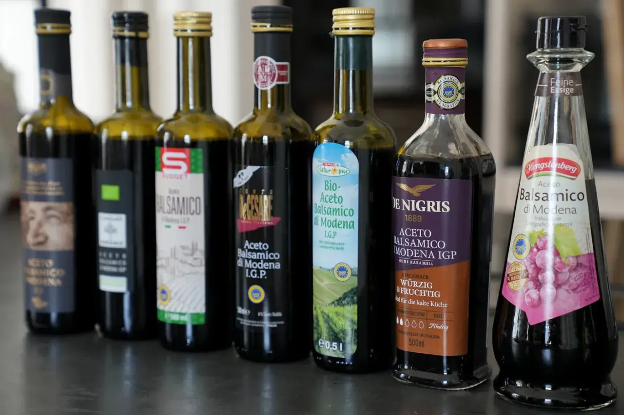 Reihe von Flaschen mit Aceto Balsamico di Modena, darunter Bio-Aceto Balsamico und Hengstenberg Feine Essige.