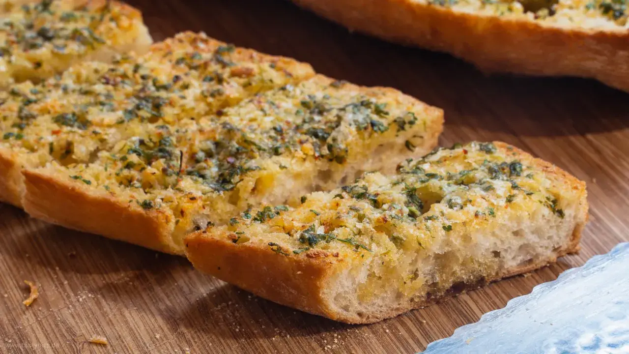 Knoblauchbrot selbst machen ist einfach! Hier sind knusprige Scheiben Baguette mit Butter, Knoblauch und Kräutern belegt, bereit zum Genießen.