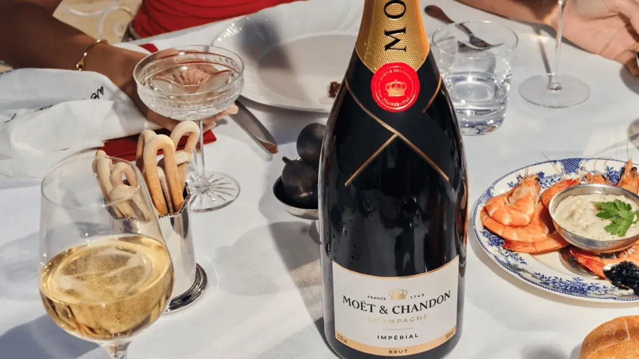 Elegante Tafel mit Moët & Chandon Champagner, Garnelen und Brot. Die Herkunft des Champagners ist unverkennbar.
