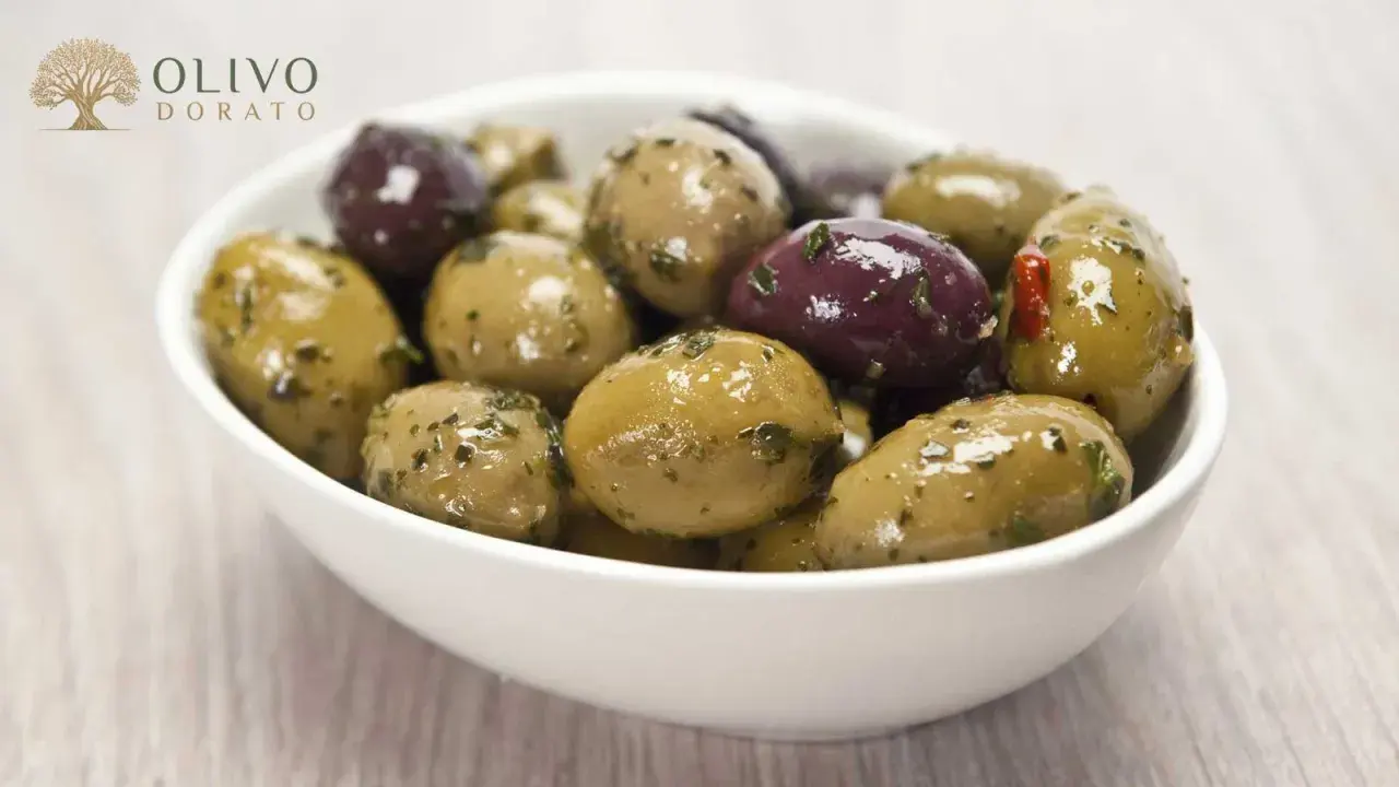 Schüssel mit grünen und violetten Oliven, mariniert mit Kräutern. Perfekt zum Oliven einlegen.