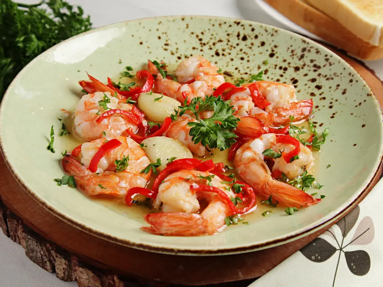 Garnelen in Knoblauchöl mit Paprika und Petersilie, ein köstliches Gericht, das perfekt zu einem Glas Wein passt.