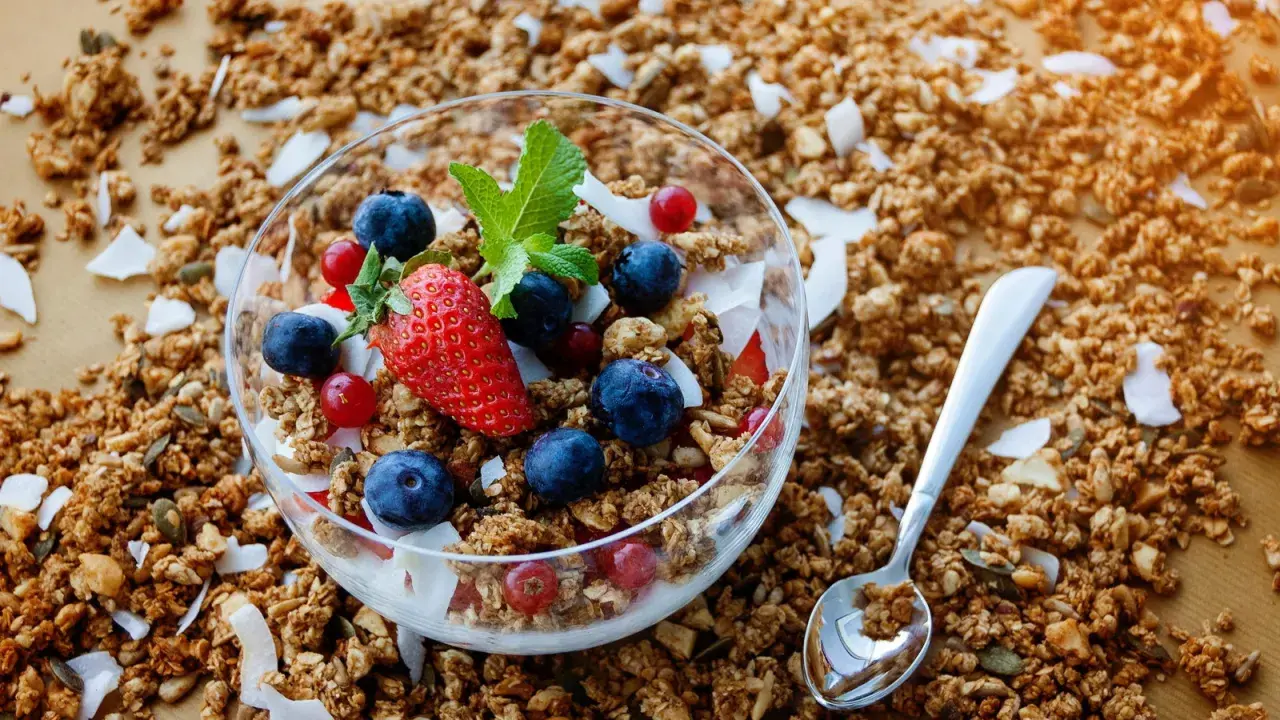 Knuspriges Granola mit Beeren und Kokosflocken in einer Schale. Was ist Granola? Ein leckeres Frühstück!