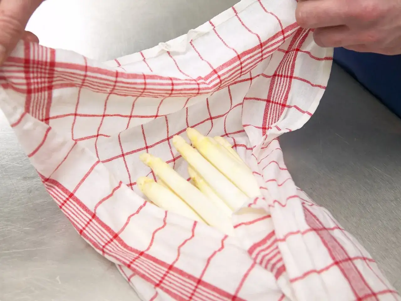 Gekochter Spargel in einem Küchentuch. Wie lange haltbar? Kühl und feucht lagern.