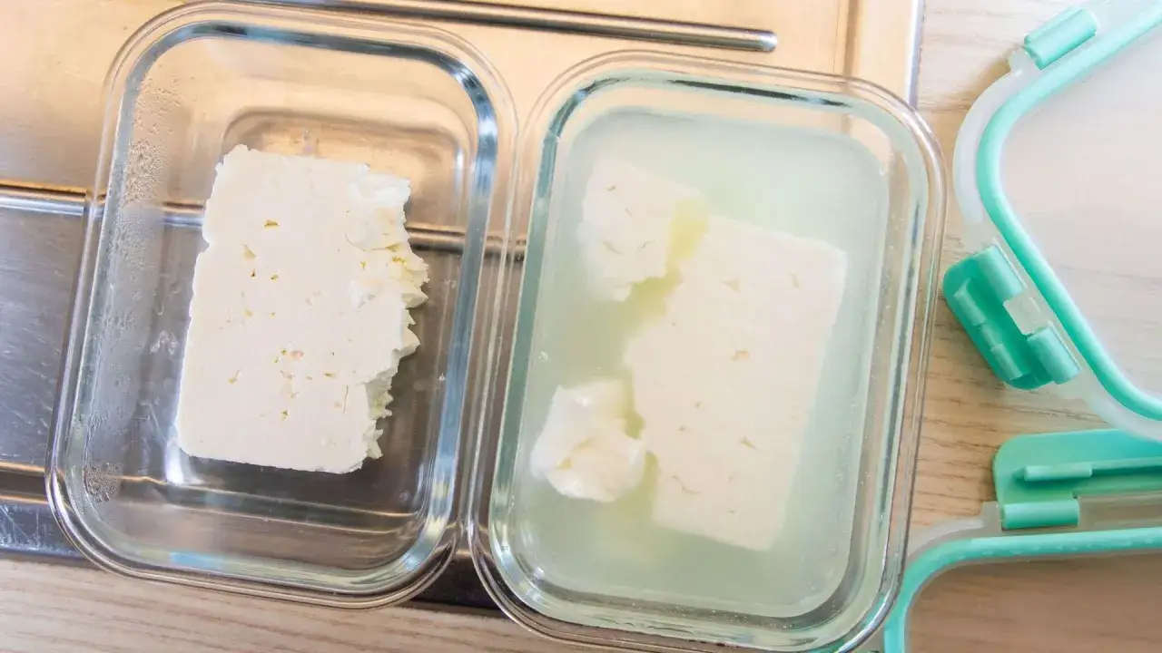 Zwei Glasbeh&auml;lter mit Feta. Einer trocken, der andere in einer leicht schleimigen Fl&uuml;ssigkeit.