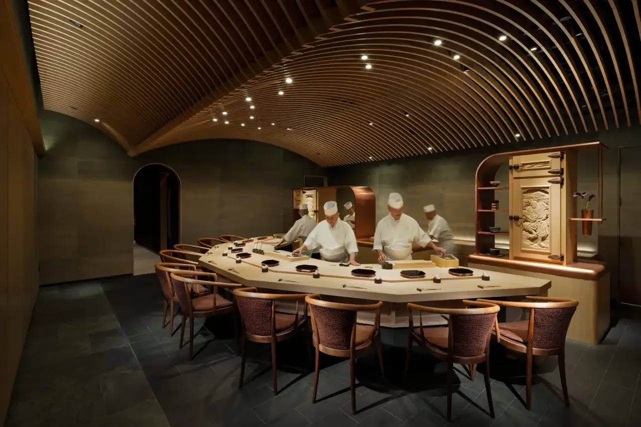 Köche bereiten das teuerste Sushi der Welt in einem eleganten Restaurant mit geschwungener Holzdecke zu.