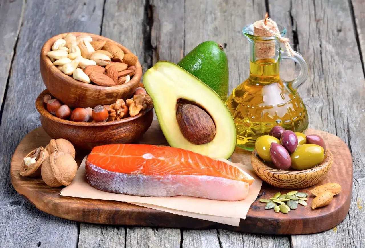 Lachsfilet, Avocado, Nüsse, Oliven und Öl – alles gesunde Fette zum Braten und Genießen.