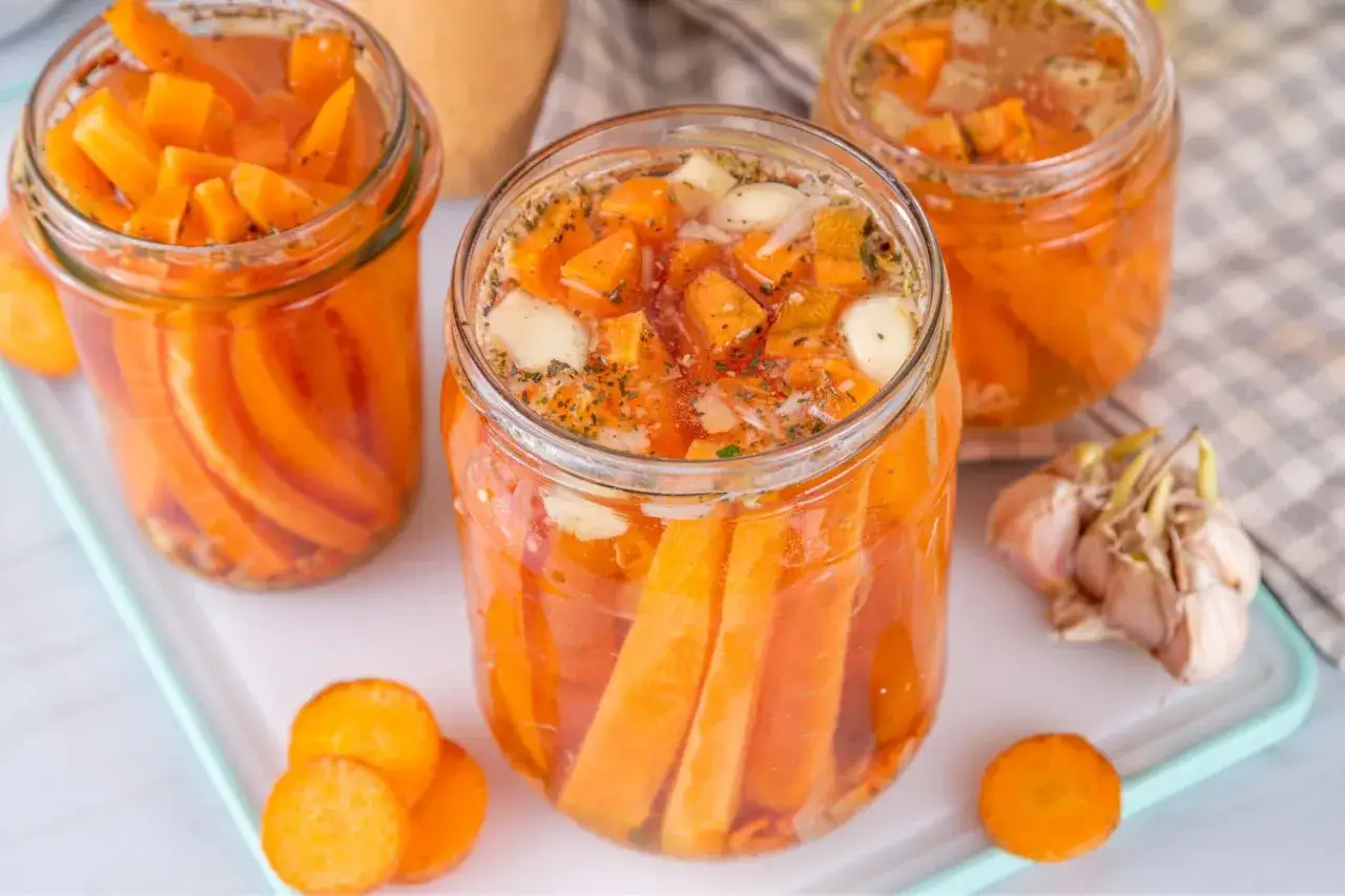 Gl&auml;ser mit karotten fermentieren, gef&uuml;llt mit geschnittenen Karotten, Knoblauch und Gew&uuml;rzen. Ein gesunder Prozess f&uuml;r leckere Beilagen.